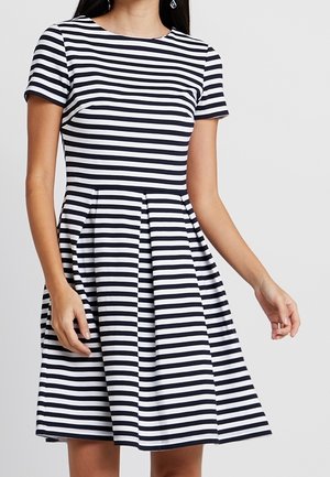 Marineblå og hvide stribede kortærmede kjole med tætsiddende overdel og udslået nederdel, lavet af en glat stof. Har en rund halsudskæring.