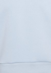 Ljust blå sweatshirt med mjukt material, utrustad med ribbad nederkant och ärmslut. Slät tyg, enkel design, inga synliga mönster eller detaljer.