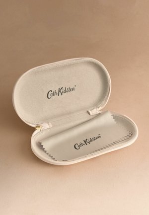 Béžové puzdro na okuliare značky Cath Kidston otvorené s odpovedajúcou čistiacou handričkou vo vnútri na svetlohnedej ploche.