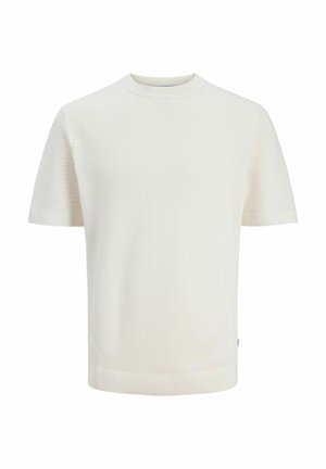 Īsām piedurknēm, krēmkrāsas adīts džemperis ar apaļu kakla izgriezumu un smalku teksturētu rakstu, attēlots uz baltas vienkāršas fona.