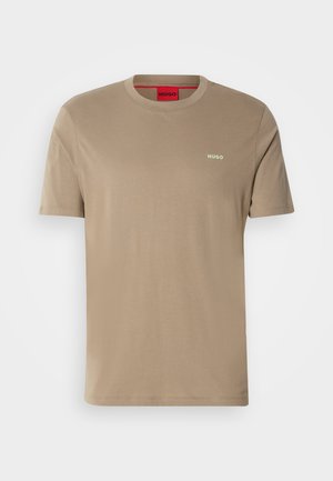 T-shirt en coton beige avec col rond, manches courtes et petit logo "HUGO" vert sur la poitrine. Texture lisse, coupe décontractée.