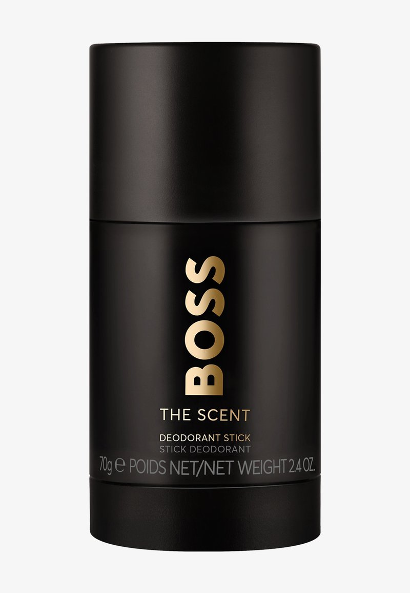 Zwarte cilindrische deodorantstick met gouden "BOSS"-logo en tekst "THE SCENT", gewicht 70 g, en "DEODORANT STICK" op het etiket.