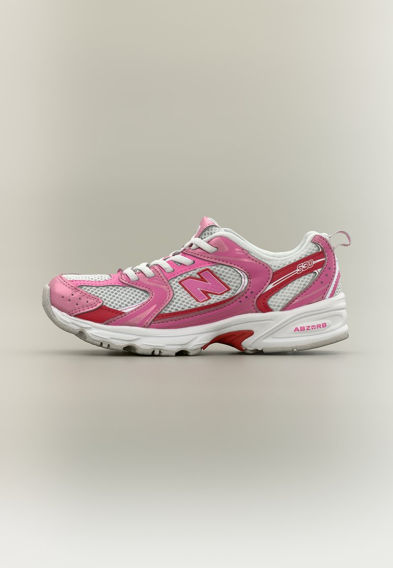 Αθλητικό παπούτσι New Balance 630 σε λευκό και ροζ, με πλέγμα στα πάνελ, λογότυπο στο πλάι, μαλακή σόλα και κορδόνια στο μπροστινό μέρος, εμφανιζόμενο σε πλευρικό προφίλ.