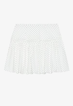 Jupe blanche à design à niveaux, avec des pois noirs. Fabriquée en tissu léger avec un ourlet froncé pour plus de texture.