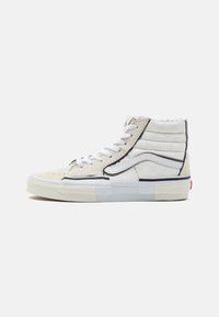 Høje sneakers i off-white ruskind og lærred. Har sorte syninger, hvide snørebånd og en struktureret gummisål med rød accent.