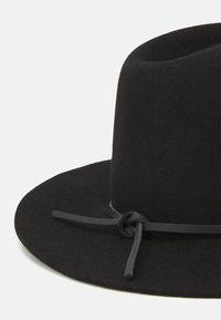 Black felt hat featuring a wide brim and a knotted black leather band around the base, with a structured crown.