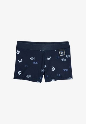 Shorts de bain bleu marine avec des motifs marins blancs comprenant des poissons, des crabes, des vagues et des algues, avec une étiquette « Restez au frais » sur la ceinture.
