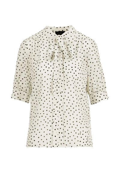 Rövid ujjú krémszínű blúz fekete pöttyökkel, masnis gallérral, gombos elülső résszel és vállnál összegyűrt részletekkel.
