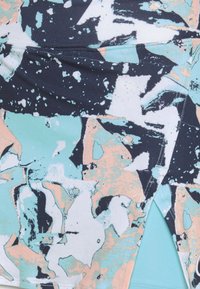 Flerfärgad sporttyg med ett abstrakt mönster i marinblå, ljusblå och korallfärger. Slät textur med synliga sömdetaljer.