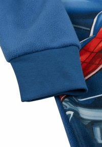 Indumento in pile blu con polsini a costine e un design colorato con una stampa di un personaggio in evidenza. Texture morbida e stile casual.