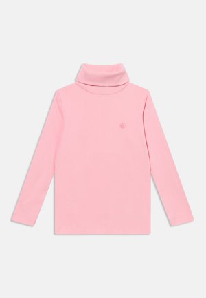 Chemise à col roulé rose à manches longues avec un petit emblème discret sur la poitrine, présentée sur un fond clair uni.