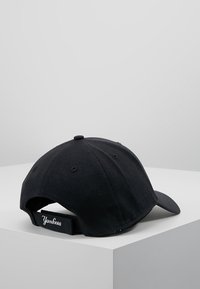 Schwarze Baseballmütze aus Stoff mit gebogenem Schirm, verstellbarem Riemen auf der Rückseite und weißem gesticktem Logo auf dem Riemen.