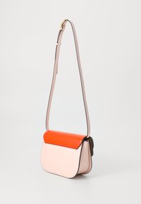 Bolso bandolera de cuero estructurado en rosa suave con una solapa roja brillante; cuenta con una correa ajustable delgada y un borde negro.