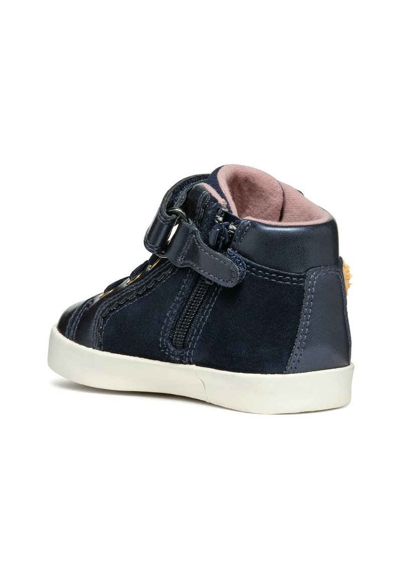 Baskets montantes bleu marine en mélange de suède et cuir, avec une fermeture éclair sur le côté, une sangle ajustable, une semelle en caoutchouc blanche et un intérieur rose.