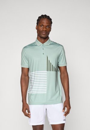 Polo en tissu vert clair, avec un design géométrique comportant des lignes et des rayures diagonales en vert foncé et blanc. Manches courtes.