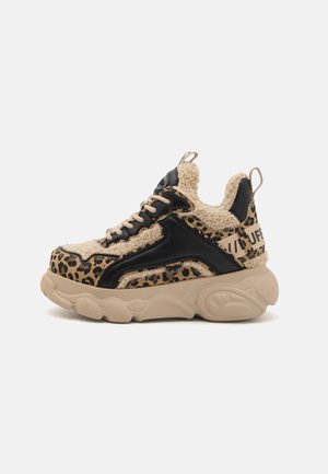 Sneakers w print zebra w odcieniach beżu i czerni, z pluszowym materiałem, grubą gumową podeszwą oraz kontrastującymi czarnymi akcentami po bokach.