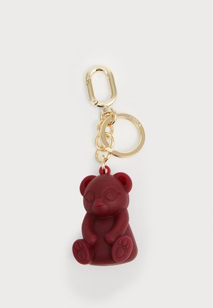 Portachiavi in silicone bordeaux con accessori in tono oro, dotato di un anello diviso e di una chiusura ad uncino per l'attacco, con una finitura testurizzata.