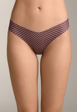 Close-up van het middenstuk met een bruine bikini-onderbroek met stippen tegen een neutrale achtergrond.