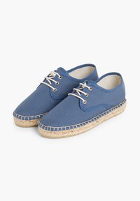 Scarpe in tela blu con lacci in cotone beige, punta rotonda e suola in juta con texture intrecciata. Presentano dettagli cuciti lungo la suola.