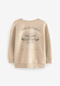 Beige sweatshirt med rund hals, sänkt axel, ribbade ärmslut och en tryckt grafisk logotyp i mörka färger på framsidan.