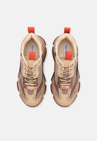 Paire de baskets en mesh beige et marron avec semelles épaisses et languettes orange vue de dessus sur fond blanc.