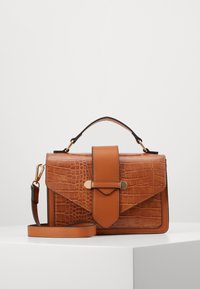 Ruskea keinonahkainen käsilaukku krokotiilitekstuurilla, läppäkiinnitys ja irrotettava olkahihna. Varustettu kullanvärisillä yksityiskohdilla.