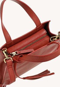 Sac à main en cuir rouge avec un compartiment zippé, une finition texturée, des ferrures dorées et des poignées doubles. Comprend une bandoulière amovible.