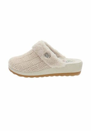 Chausson en tricot beige avec un col duveteux, arborant un emblème rond et une semelle blanche texturée avec un profil en brun clair.