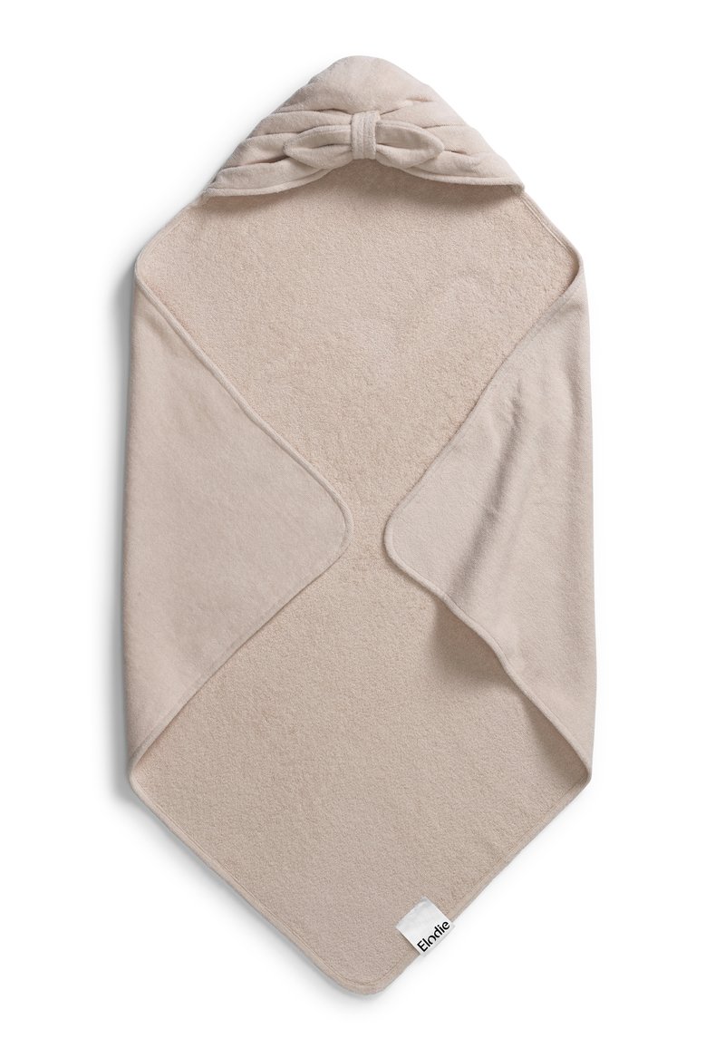 Beige huvad handduk gjord av mjukt, plyschigt tyg. Har en snurrad rosett som accent längst upp och en liten varumärkesetikett på kanten.