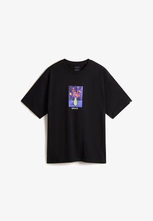 T-shirt en coton noir à manches courtes avec un graphique coloré représentant un arrangement floral dans un vase, centré sur le devant.