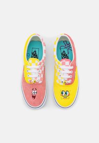 Des baskets multicolores en daim rose et toile à carreaux jaune. Personnages brodés et lacets blancs. Lettres "BEST BUDS" sur le dessus.
