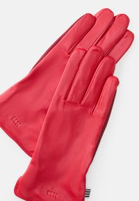 Red leather gloves with a smooth texture, featuring a simple design, embossed "MN" logo, and soft lining. Accurate fit with defined fingers.