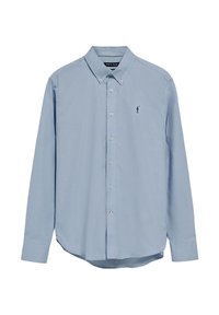 Knapp-up långärmad skjorta i ljusblå bomull med klassisk krage och en liten svart golfare-logotyp på bröstet. Mjuk textur.