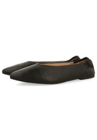 Zapatos planos de cuero negro con un diseño de punta afilada, textura suave y sutiles detalles de costura a lo largo de los bordes. Suela de goma delgada.