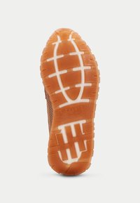 Gummisula med ett texturerat mönster som har spår och upphöjda element. Orange färg med vita accenter och varumärkesdetaljer.