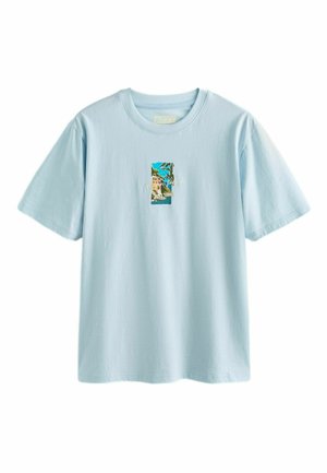 Jasnoniebieska koszulka z krótkim rękawem z niewielką prostokątną grafiką nadmorskiego krajobrazu na środku, przedstawiającą klif, dom i ocean.