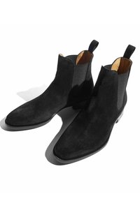 Botas Chelsea de ante negro con puntas afiladas, paneles laterales elásticos y lengüetas de tiro. Presentan un diseño elegante y un acabado texturizado.