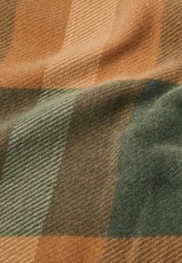 Tessuto di lana a quadri caratterizzato da calde tonalità di arancio, verde e crema, con una morbida texture e un motivo a trama diagonale.