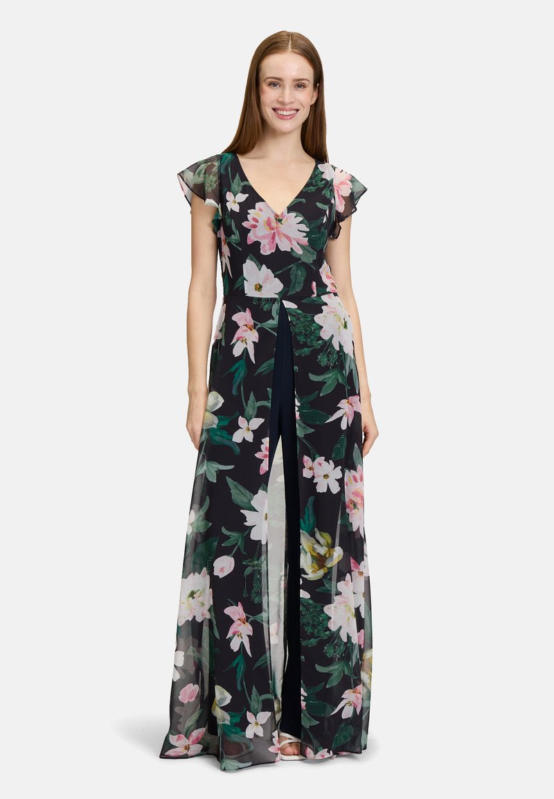 Robe maxi florale en tissu sombre avec de grands motifs floraux roses et verts, à manches courtes évasées et une fente frontale pour plus de mouvement.