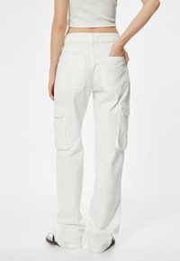 Pantaloni cargo bianchi realizzati in tessuto resistente, con tasche laterali, una vestibilità comoda e un design a gamba dritta. Le tasche posteriori sono visibili.