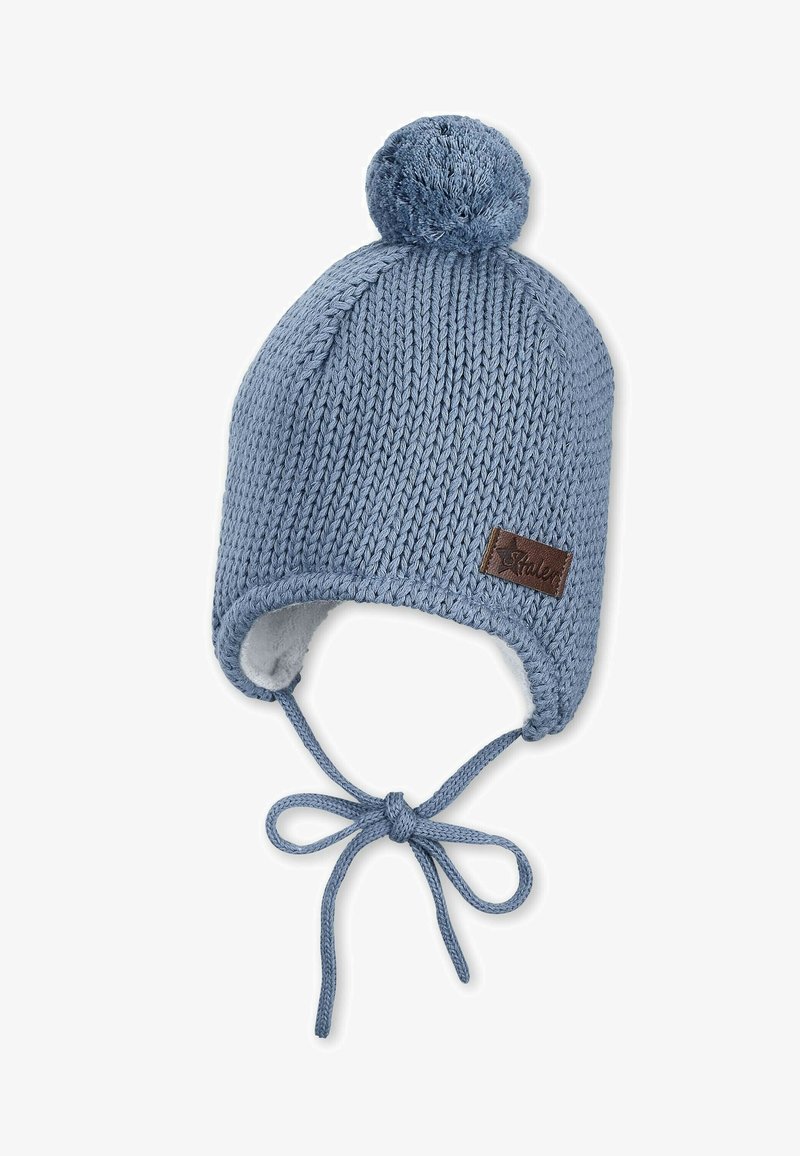 Knit hat in light blue with a pom-pom on top, featuring a soft interior lining, ear flaps, and adjustable ties. Brown leather label accent.
