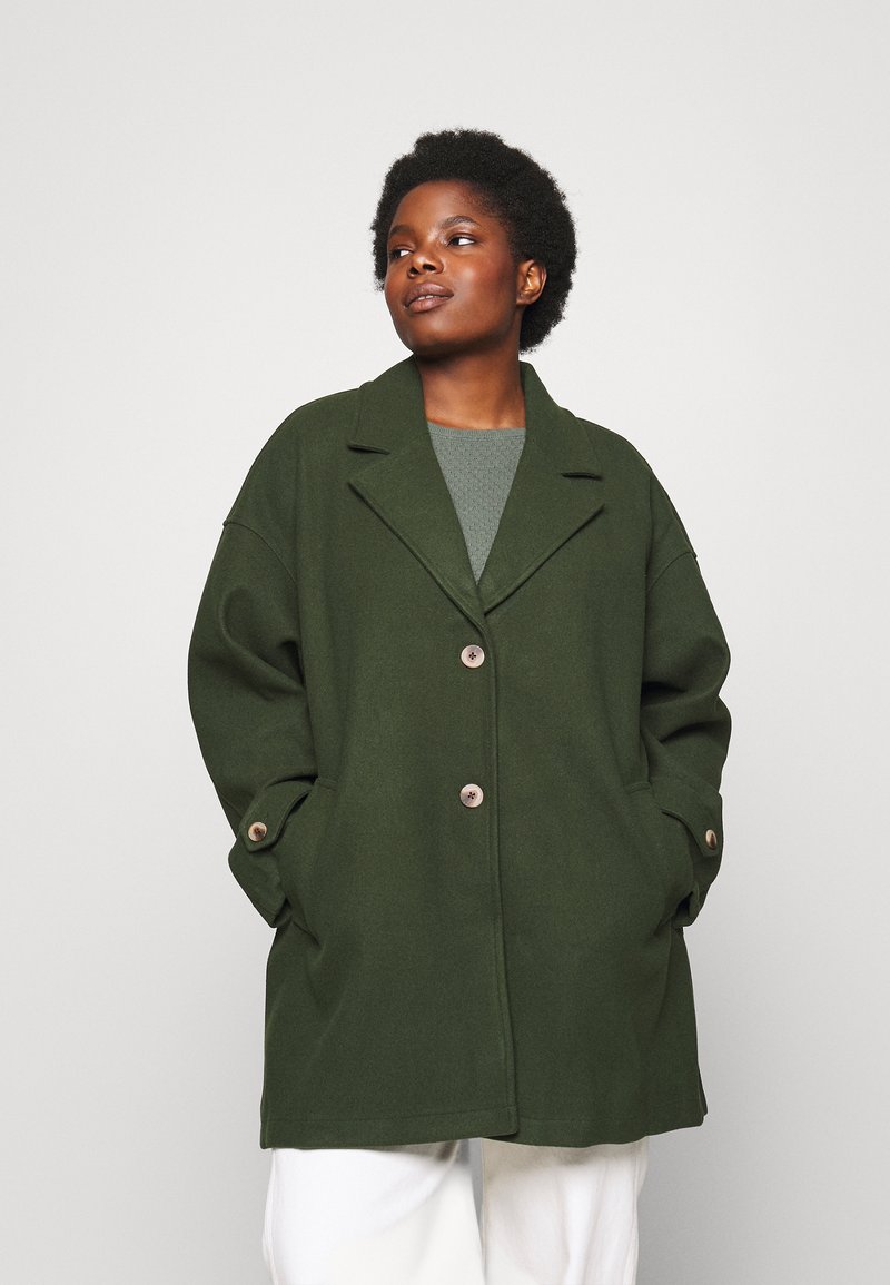 Oversized green coat, wool blend, notch lapel, two front pockets, two-button closure, subtle texture, tailored fit.