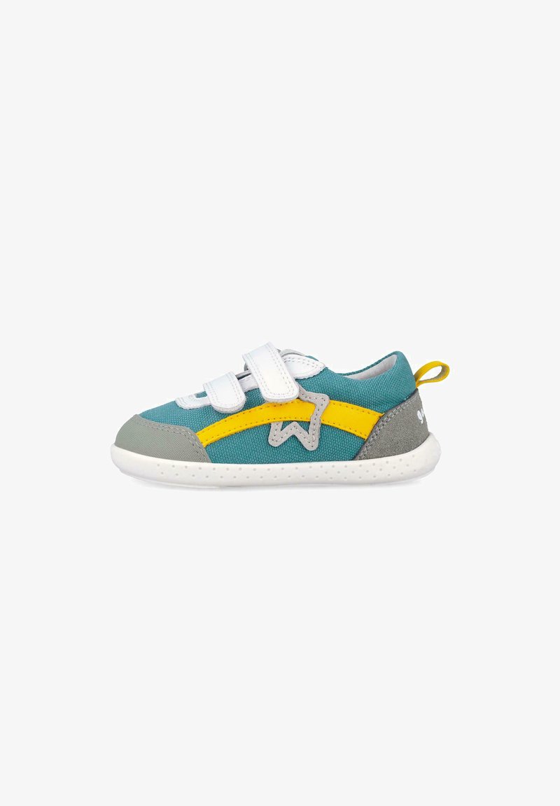 Zapatilla infantil azul con detalles en amarillo y gris, tiras de velcro blancas y suela blanca, mostrada de perfil.