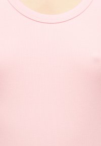 Ροζ ριμπ ύφασμα τοπ με στρογγυλή λαιμόκοψη, κοντινή άποψη εστιασμένη στην υφή και την περιοχή του γιακά.