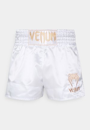 Shorts de boxe en satin blanc avec une large ceinture élastique, ornés d'un logo "VENUM" brodé en or et d'un graphisme du logo sur la jambe gauche.