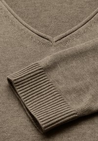 Brun stickad tröja med V-halsdesign, ribbade ärmslut och slät textur, som framhäver dess enkla, klassiska stil.