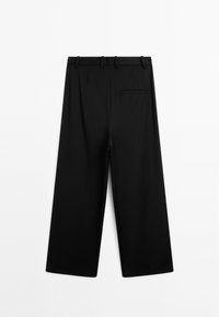 Schwarze Hose mit weitem Bein, mit Gürtelschlaufen und einer einzelnen Paspeltasche auf der Rückseite, vor weißem Hintergrund.