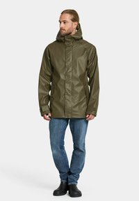 Olivgrön vattenavvisande jacka med huva, frontdragkedja och tryckknappsstängning. Har fickor på sidorna och en slät, blank yta.