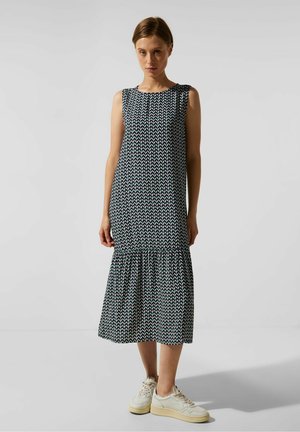 Robe midi sans manches avec un ourlet à volants, arborant un motif géométrique en bleu marine, blanc et vert. Fabriquée en tissu léger.