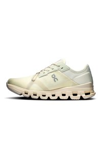 Zapatillas de running en un beige claro con un upper texturizado, diseño con cordones y una suela acolchada que cuenta con recortes para mayor flexibilidad y soporte.